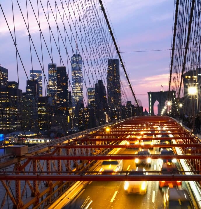 A view of the brooklyn bridge at night.