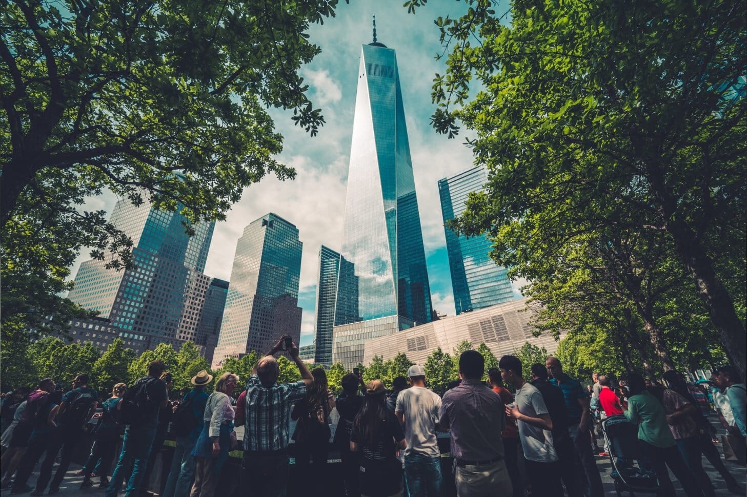 A group of people standing around in front of tall buildings.